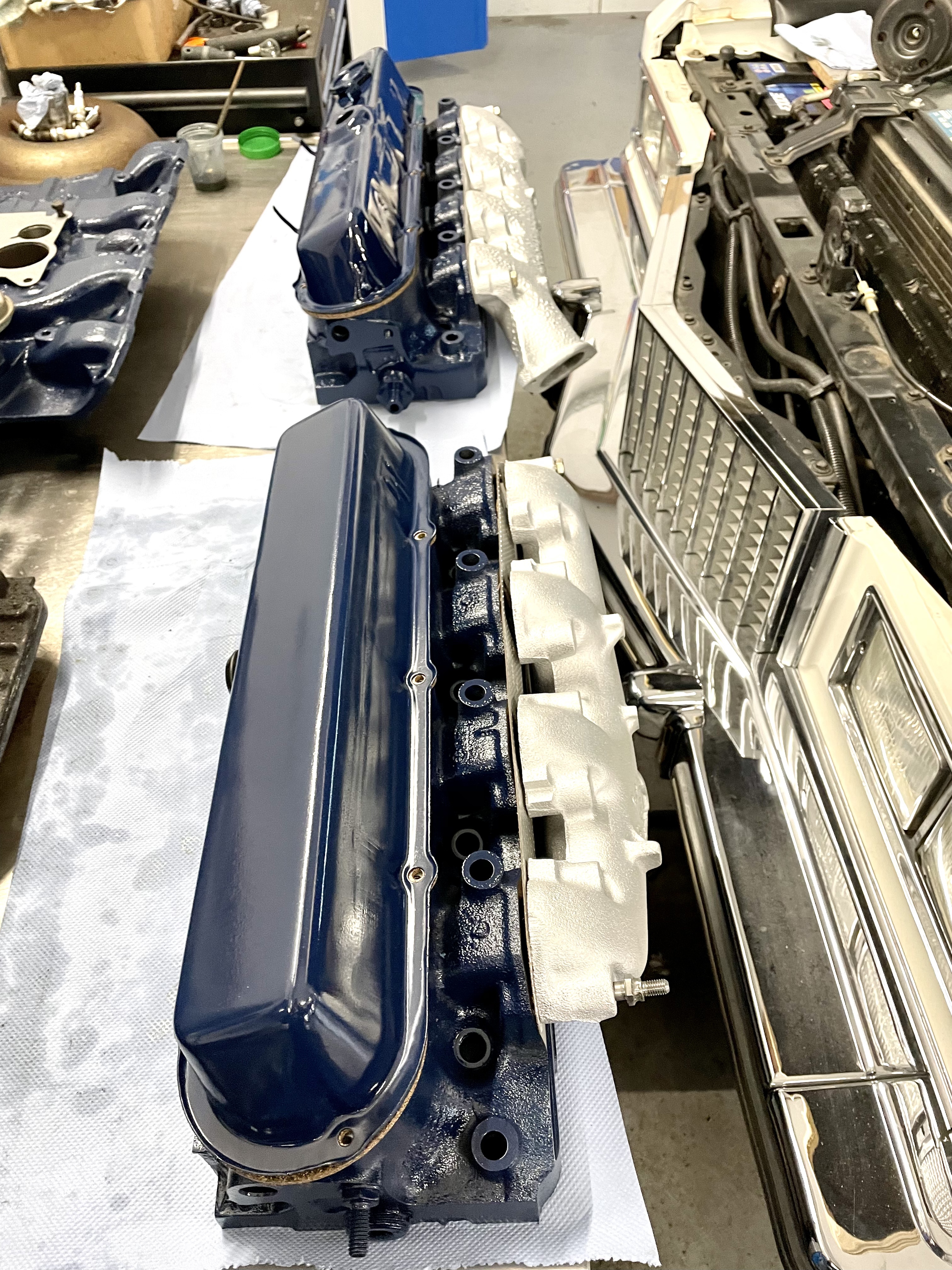 Blaue Motorventildeckel in einer Werkstatt für klassische US-Fahrzeuge (Cadillac, Lincoln, 1956–1979) während der Restauration.